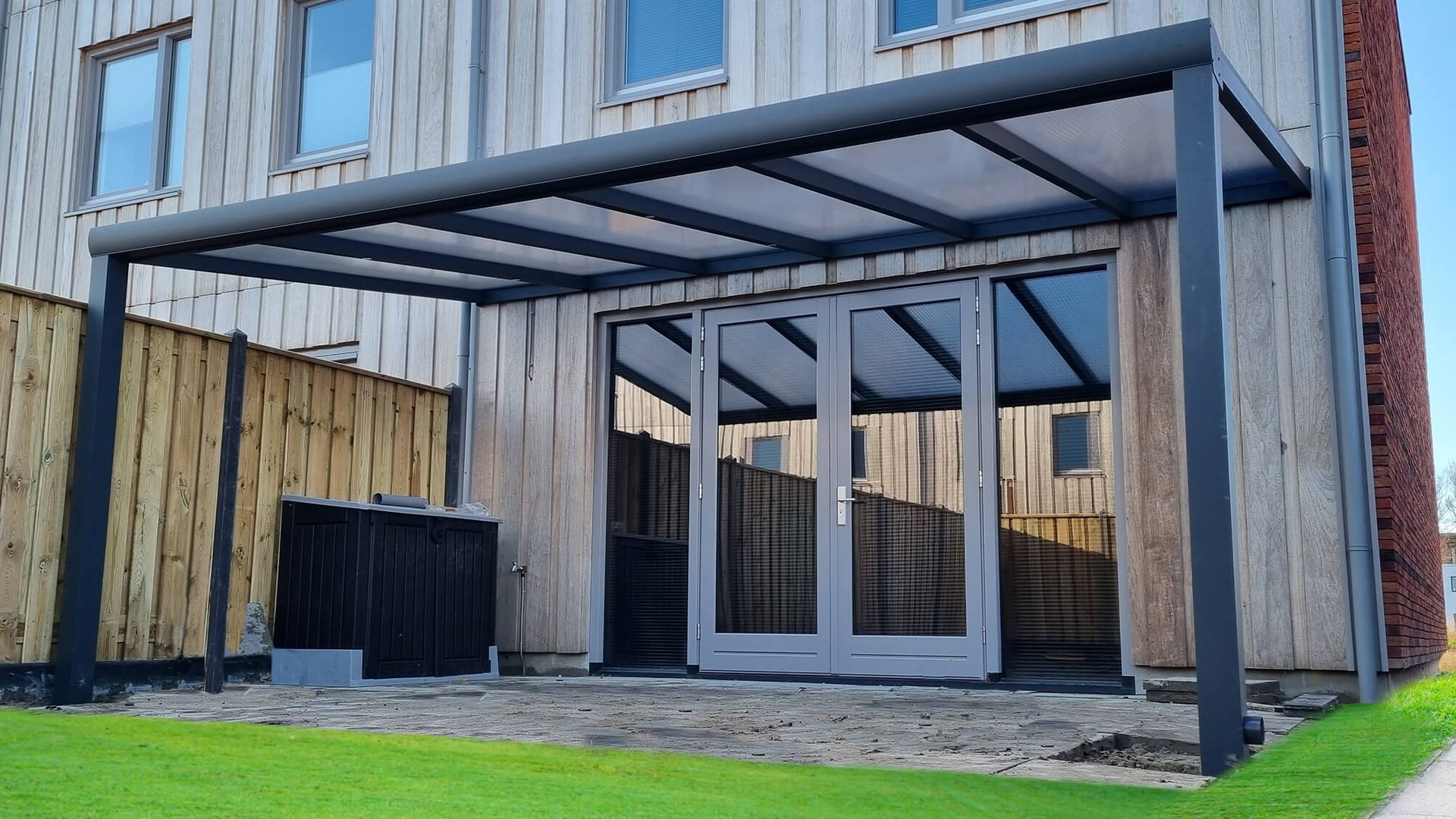 Aluminium veranda met glazen schuifwand aan een woning
